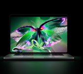 MacBook Pro mit PROLED XDR Display, geöffnet, Farbe Silber, das Display zeigt ein detailliertes, kontrastreiches Bild mit lebendigen Farben, der Bildschirm beleuchtet die Tastatur